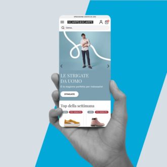 Mano tiene smartphone con pagina di calzature del sito Scarpe & Scarpe.